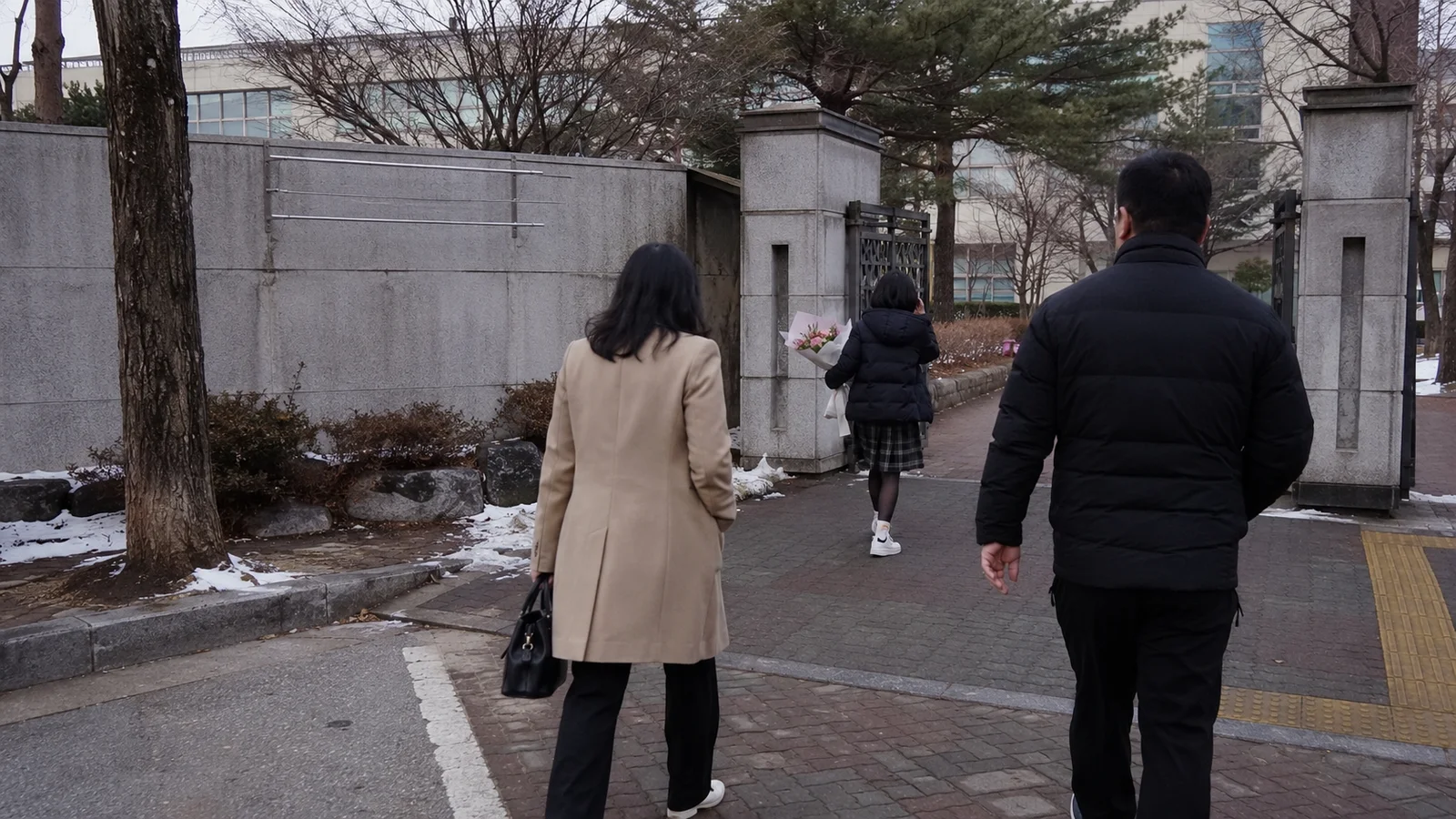 졸업식 날 꽃다발을 들고 교문을 나서는 학생의 뒷모습