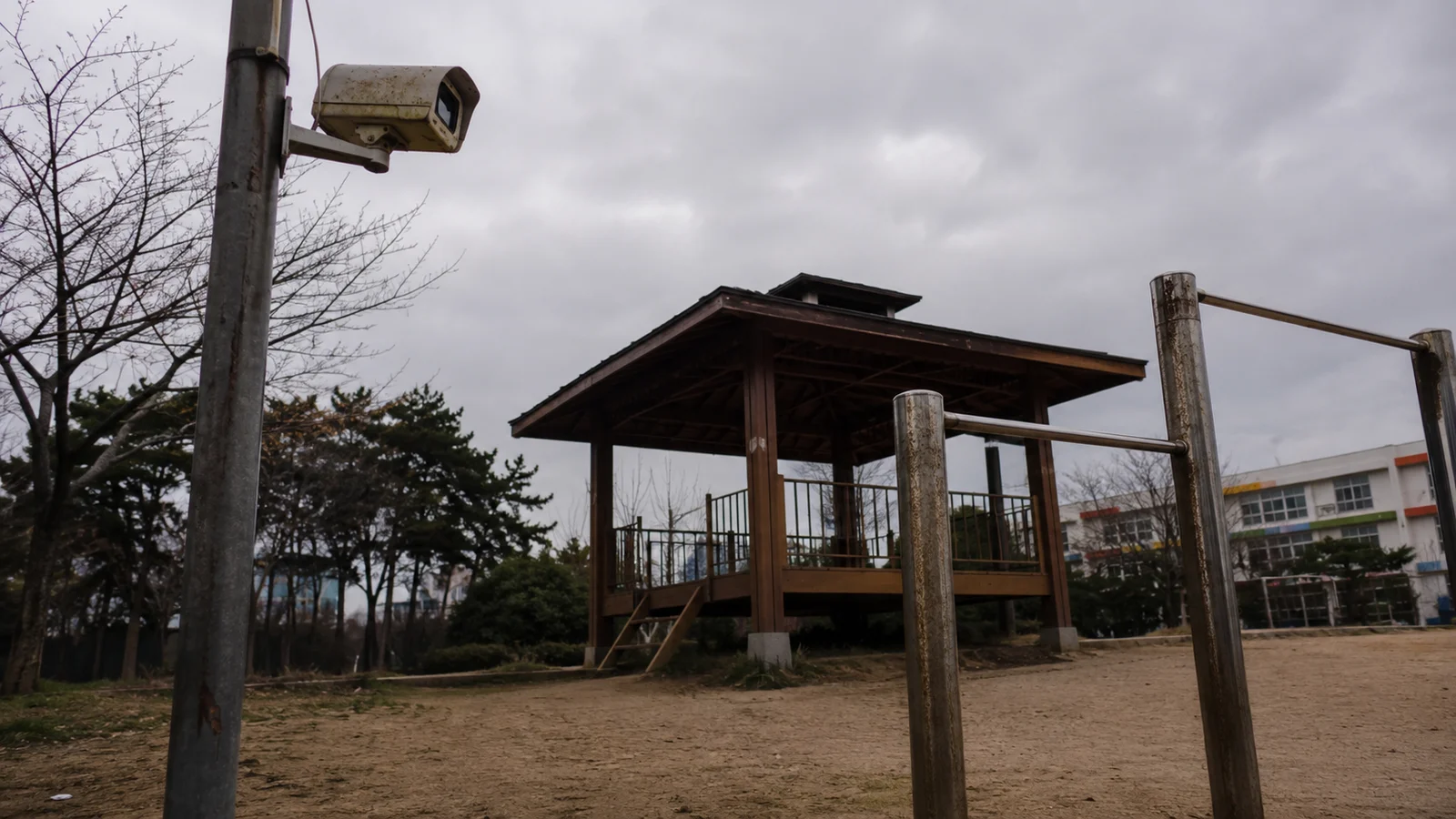 학교 운동장의 정자와 기둥에 달린 낡은 방범 카메라