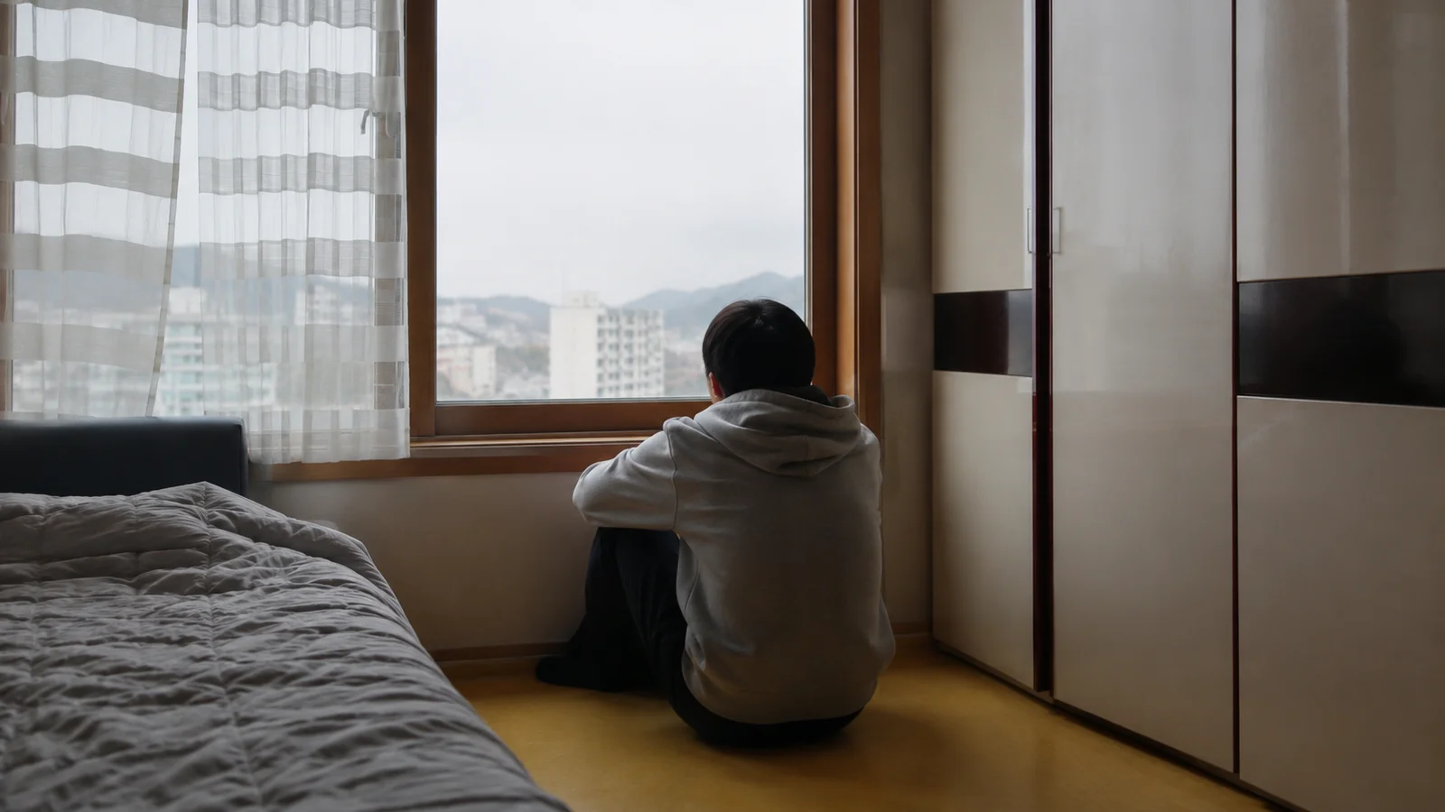 방 안에서 홀로 웅크린 학생