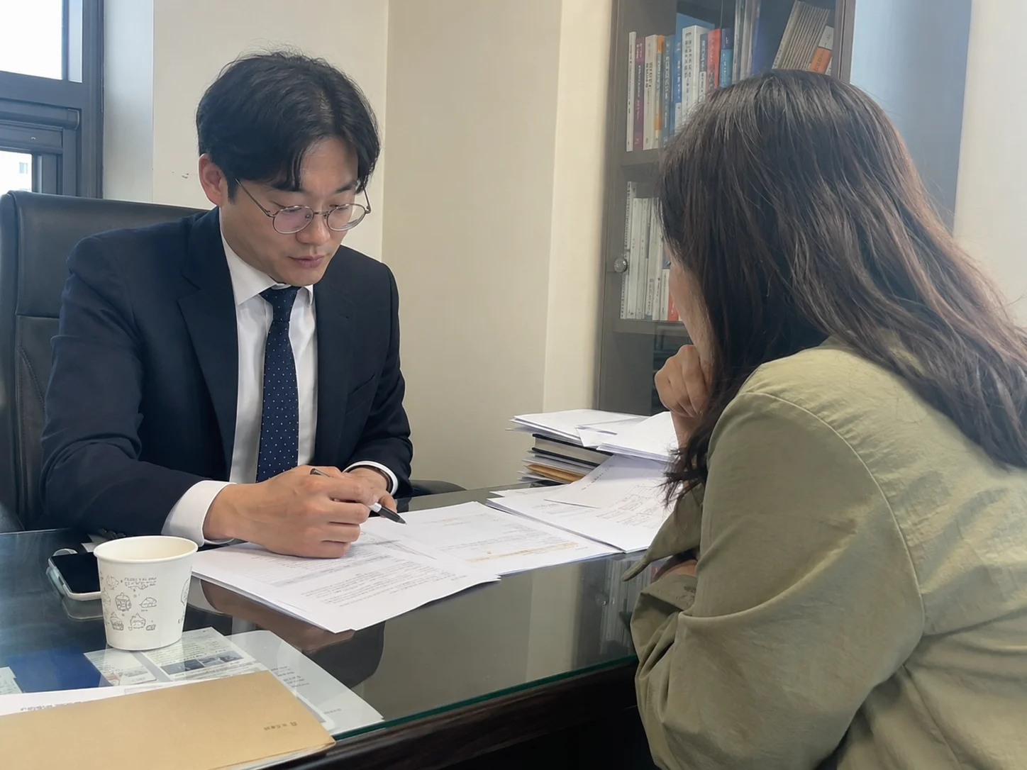 상담실에서 서류를 사이에 두고 상담하는 변호사와 학부모