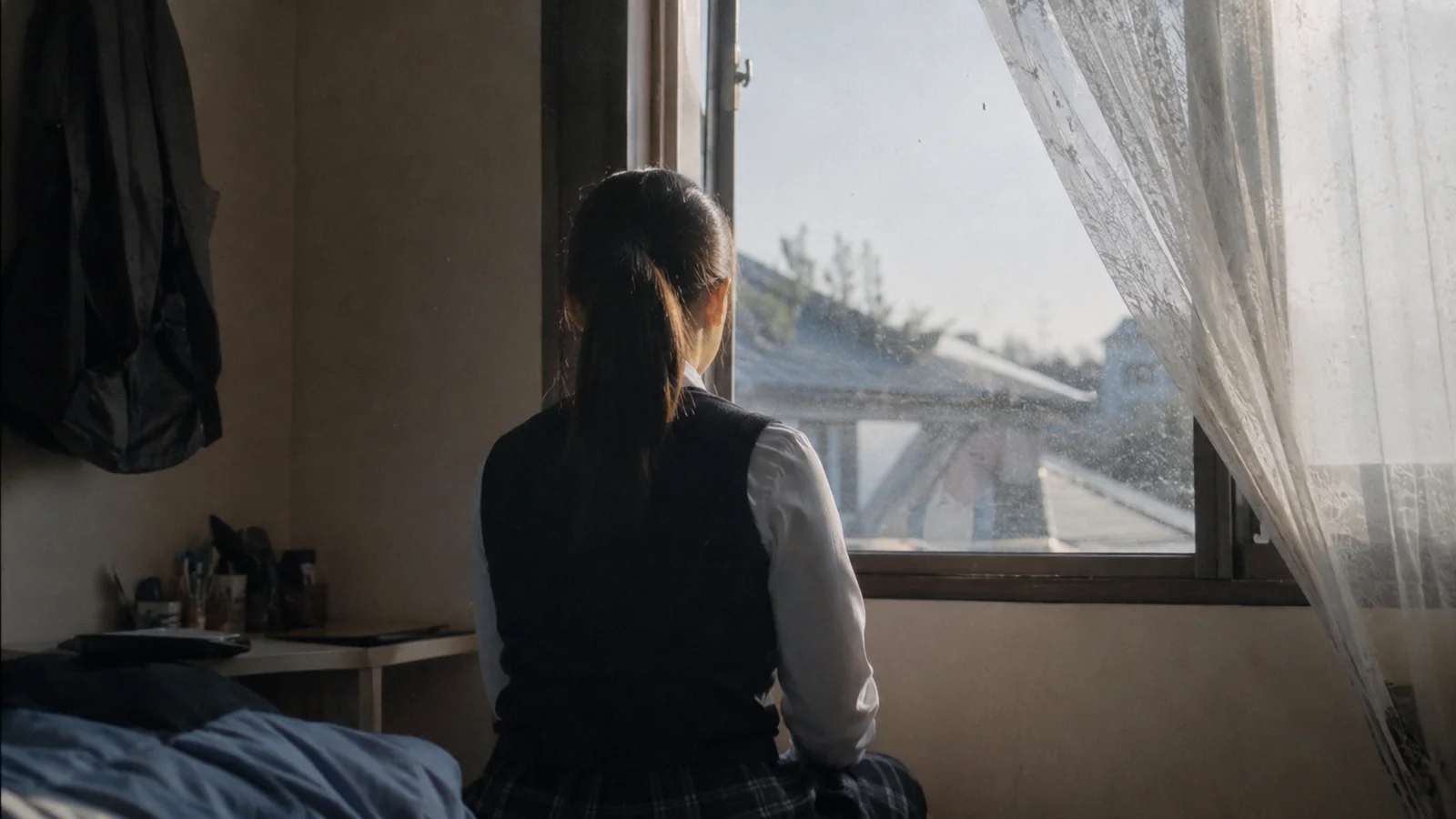 오후 늦게 창가에 앉아 생각에 잠긴 학생의 뒷모습