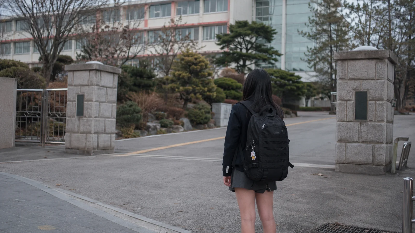 학교 앞을 지나는 학생과 학교 건물