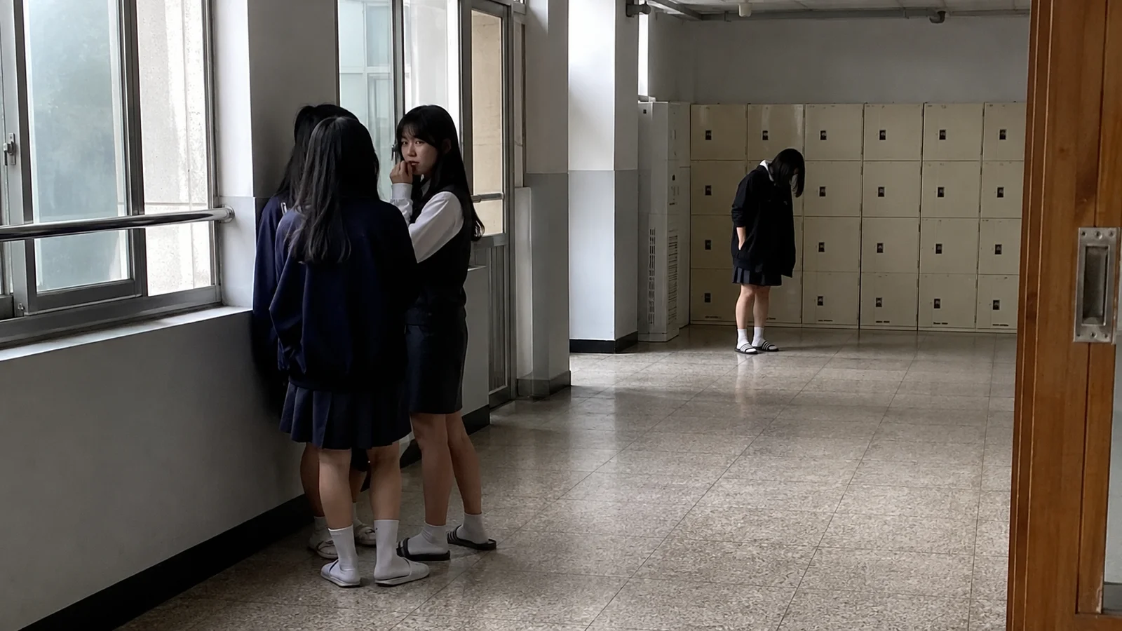 복도에서 소문이 오가는 모습